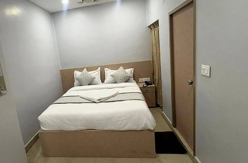 Double Deluxe room with a wooden bed and soft grey walls