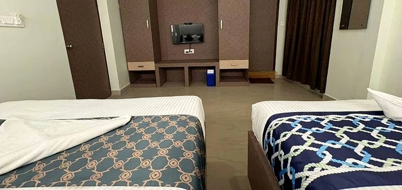Quadruple room with two double beds and a TV unit
